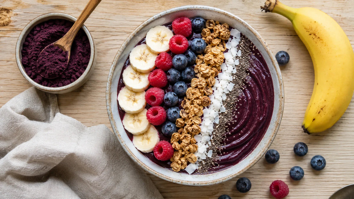 Acai bowl maison violet garni de granola, banane, fruits rouges et graines de chia